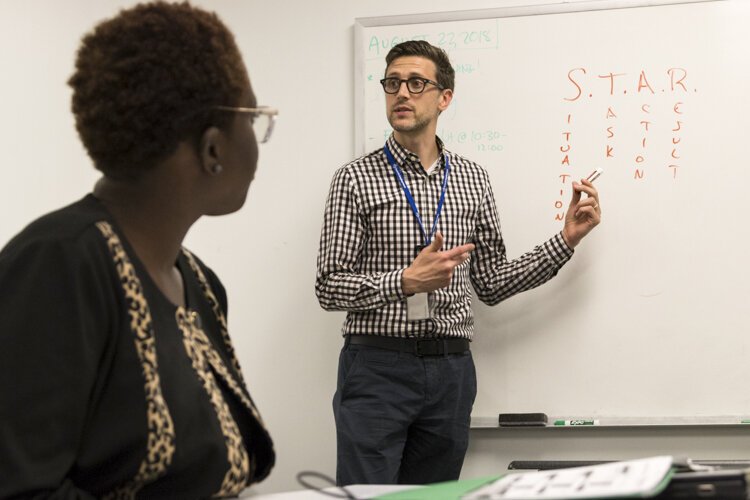 <span class="content-image-text">A staff member at the Young Adult Resource Center at OhIoMeansJobs|Cleveland-Cuyahoga County is teaching young adults interviewing techniques and running them through mock interviews.</span>