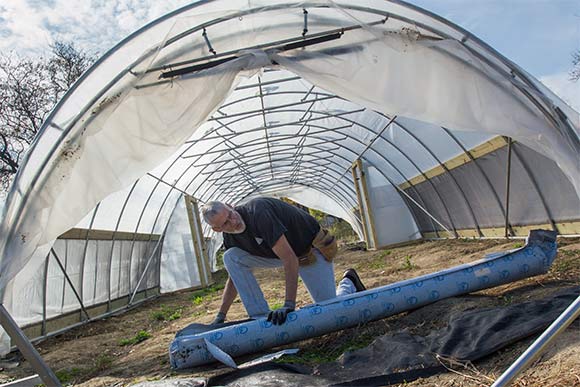 Carlton Jackson of Tunnel Vision Hoops working on a hoop house in Ohio City