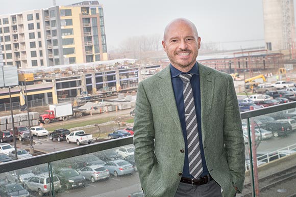 Robert Thompson CEO of Seasoned Development overlooking construction of Punch Bowl Social in the Flats East Bank