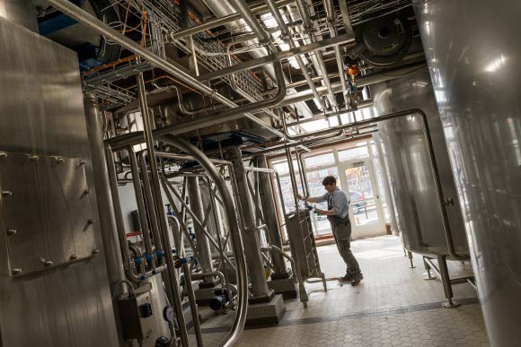 Brewer Patrick Daniels amid all the hoses and wires involved in the brewing process