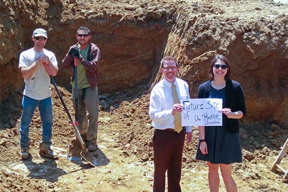 LakewoodAlive’s Ian Andrews and Allison Urbanek pose within the basement foundation of the future home at 1427 Scenic Street