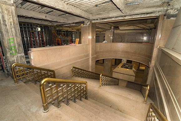 A grand marble staircase ascends from the lobby to a second floor community area