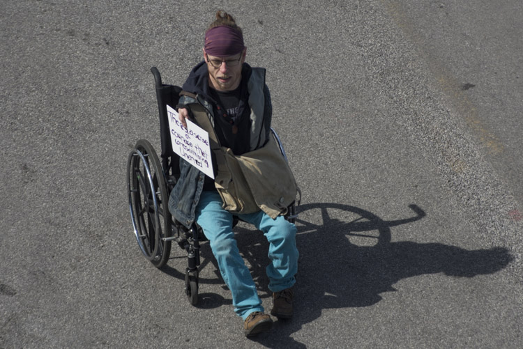 <span class="content-image-text">Sign reads: "There's a sense of courage that comes with being unarmed"</span>