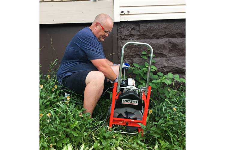 100 ft Ridgid Snake being used on a downspout donated by Ridgid Tools to the Lakewood Tool Box