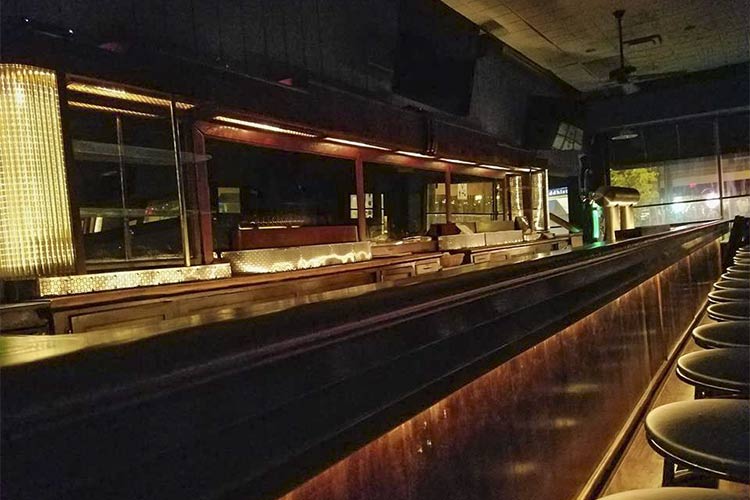 <span class="content-image-text">Behind the bar, the vintage lighting glows and highlights the refinished bar</span>