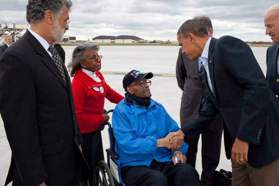 Stanley Tolliver Sr., in a wheelchair, shakes hands with President Barack Obama. Cleveland Mayor Frank Jackson is at left, and Vice President Joe Biden is at right.