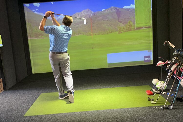 Robert “Bunk” McMahon shows off the Full Swing golf simulator at Proximity Golf Lounge.