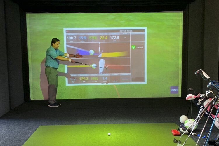 Robert “Bunk” McMahon demonstrates the Full Swing golf simulator at Proximity Golf Lounge.