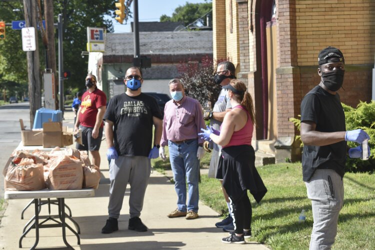 A group of volunteers prepare for cars to arrive to a food distribution event at Mt. Gillion Baptist Church in central Cleveland in mid-July.