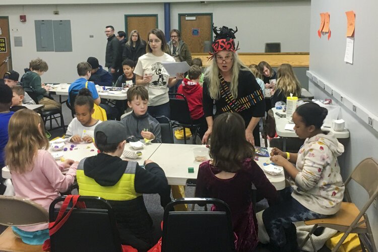 Vivian Vail, in the red and black hat, a creative arts teacher at Lake Erie Ink, oversees activities at Kids’ Comic Con.