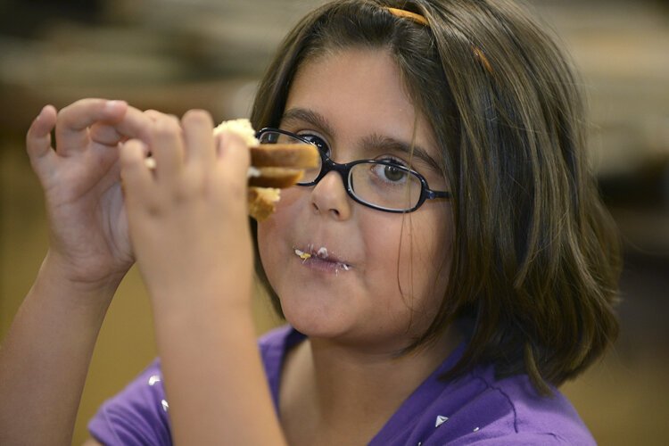 <span class="content-image-text">A child enjoys her sandwich at the summer lunch and enrichment program for kids initiated by the Lakewood Community Services Center for kindergarten through fifth graders.</span>