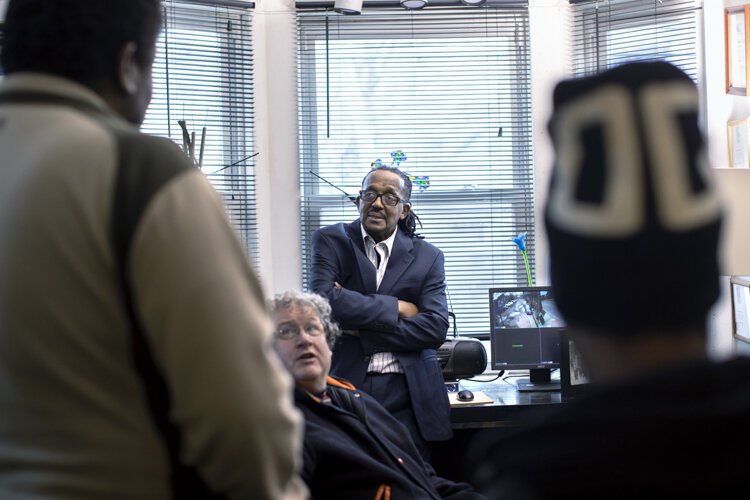 Rev. Franklin Smith talks in his office with two men who dropped in to inquire about getting help at the Manna House.