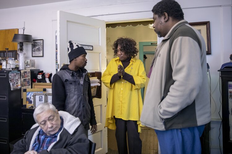 <span class="content-image-text">Angelina, a member of the Manna House team, talks with two men who stopped at Manna House to inquire about getting help.</span>