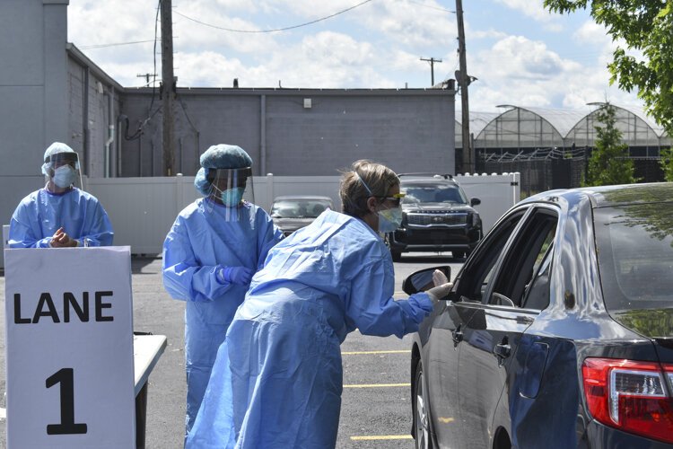 <span class="content-image-text">Dr. Heidi Gullett, center, Cuyahoga County Board of Health’s medical director, explains the process to a driver who came through a pop-up COVID-19 testing site located at the Word Church on Kinsman Road in Cleveland back in early June.</span>