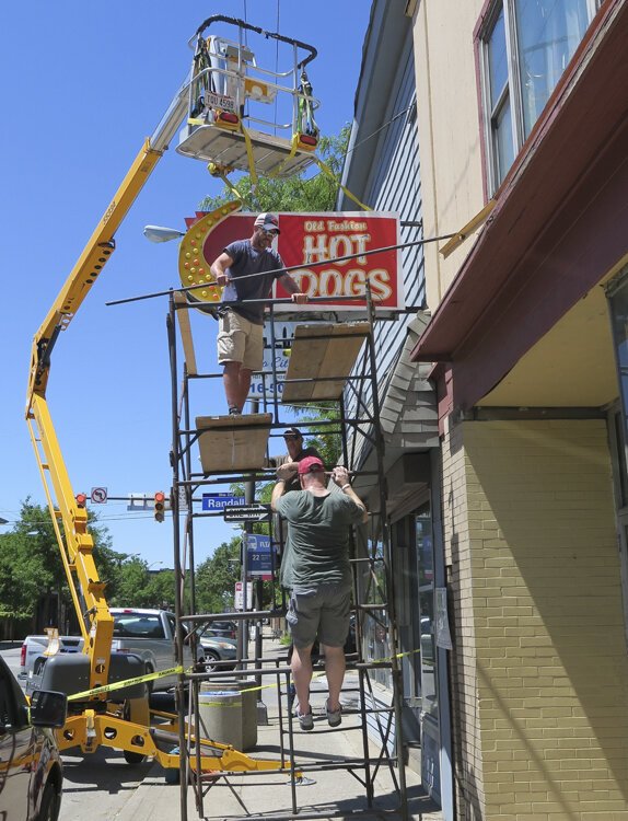 Old Fashion Hot Dogs street sign in the process of removal.