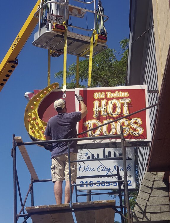 <span class="content-image-text">Old Fashion Hot Dogs street sign in the process of removal.</span>