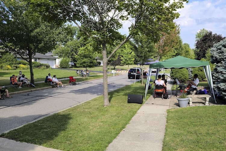 <span class="content-image-text">Musicians set up on George Carr’s front lawn as spectators watch from across the street.</span>