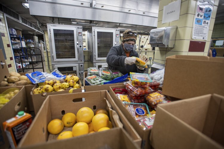 Volunteer Terri Cardy packs and weighs produce to hand out at the Campus Kitchen in Beall Hall.