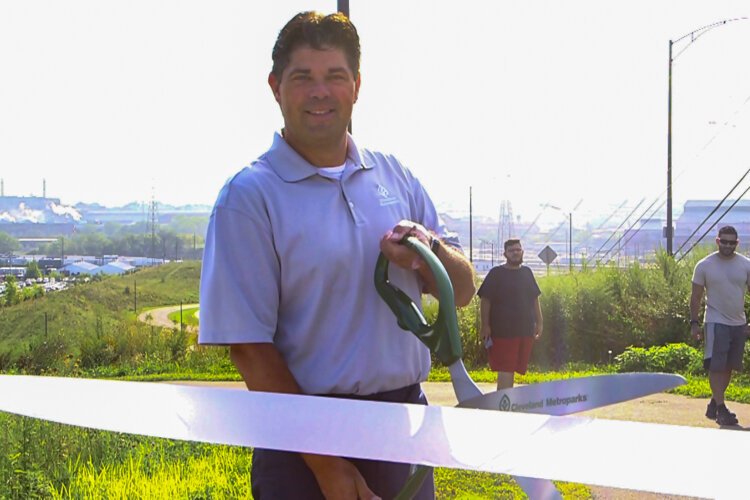 Brian Zimmerman of Cleveland Metroparks cuts the ribbon for Stage 3 of the Towpath Trail.
