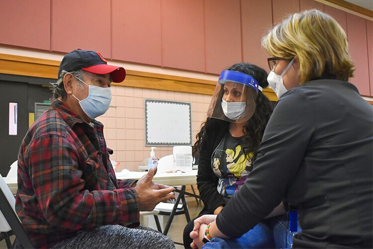 Local Resident Talks to MetroHealth Workers During Vaccination at La Sagrada Familia Church.