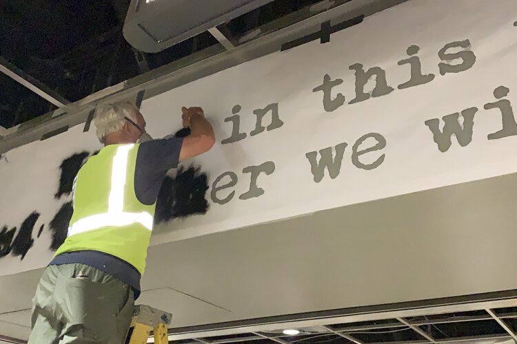 Street artist WRDSMTH working on his mural “We Are In This Together” mural at the RTA station in Tower City.