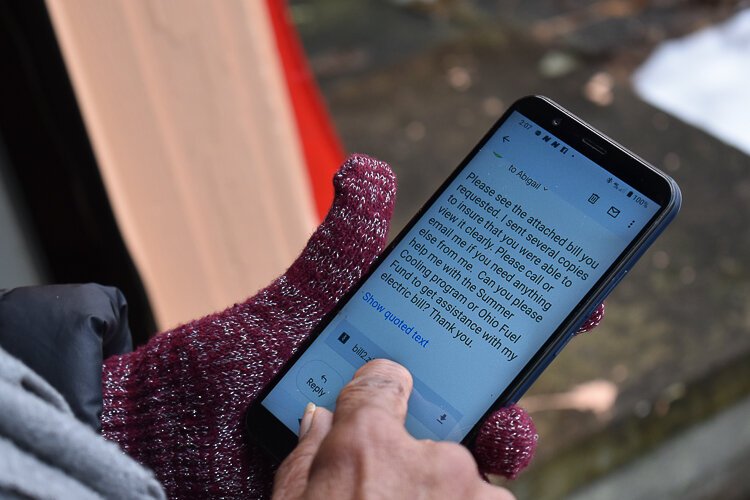 Garfield Heights resident Janet Gill-Cooks scrolls through her phone, showing the emails she’s sent in her quest to find assistance for her utility bills.