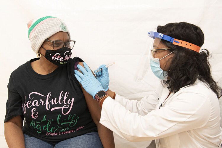 Irma McQueen receives a COVID-19 vaccine at the Langston Hughes Health and Education Center.