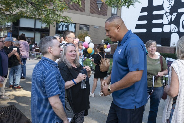 John Morrell’s son, John Jr., and Morell’s sister talking with Carl Stokes’ youngest son Cordell Stokes at the mural dedication.