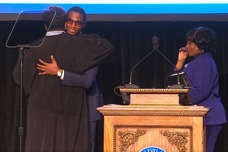 Mayor Justin Bibb hugs Ohio Supreme Court Justice Melody Stewart after being administered the oath of office as his mother, Charlene Nichols, looks on