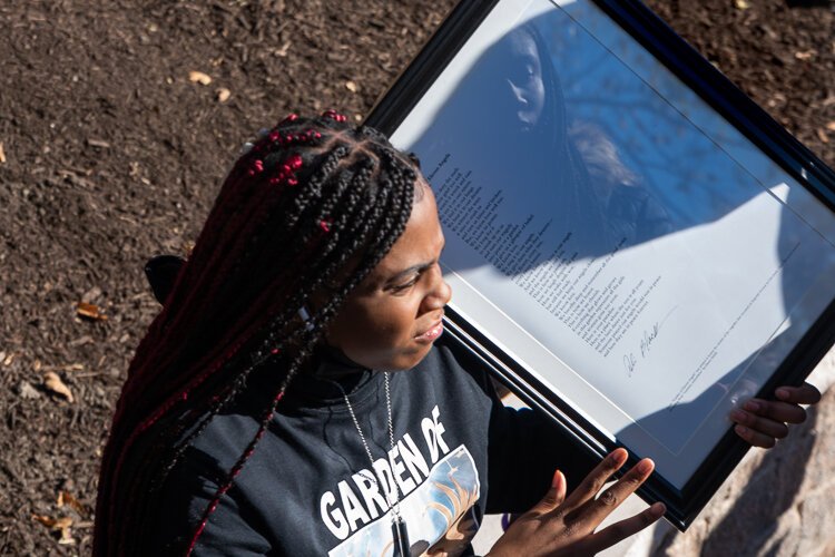 A family member of one of the Eleven Angels with a copy of the poem by Ali Black recited at the grand opening.