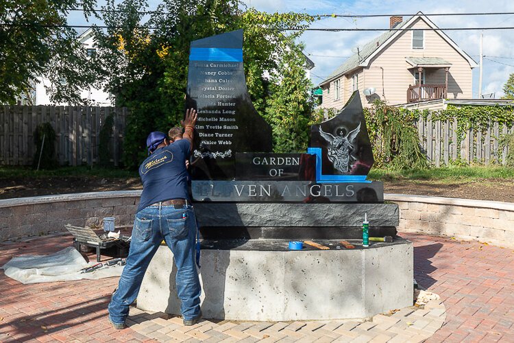 Installation of the black granite memorial at the Garden of Eleven Angels
