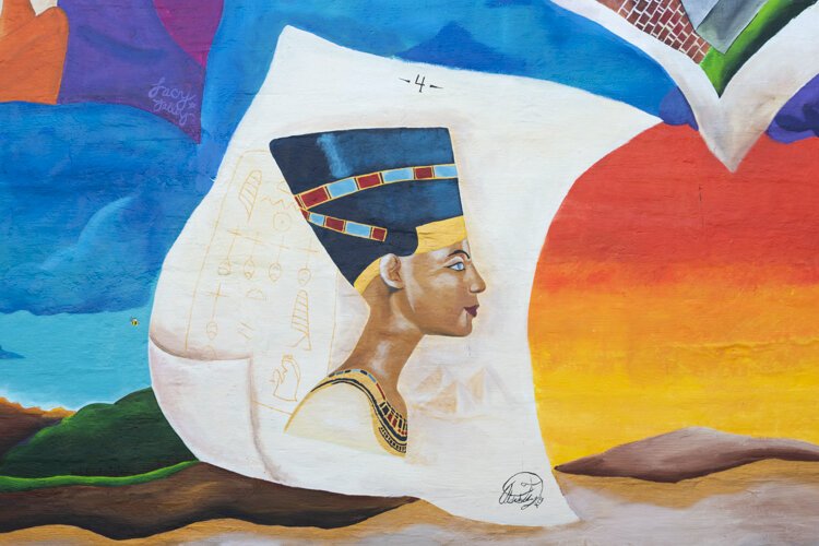 Storytime (BLM)” depicts a young Black boy under a tree, reading a story about his ethnicity and his family. The artists are Lacy “Lacerrrr” Talley, Michelle Suells, Aldonte Flonnoy, and Niquo Braxton.