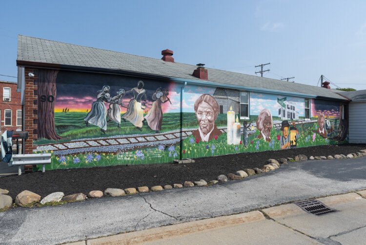 Graffiti HeArt, a  non-profit organization, engaged artists Stina Aleah, Davon Brantley, and Christa Childs for this Underground Railroad – Road to Freedom mural in Bedford.