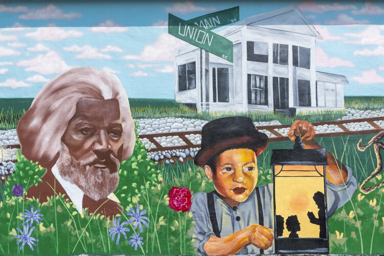 Graffiti HeArt, a  non-profit organization, engaged artists Stina Aleah, Davon Brantley, and Christa Childs for this Underground Railroad – Road to Freedom mural in Bedford.